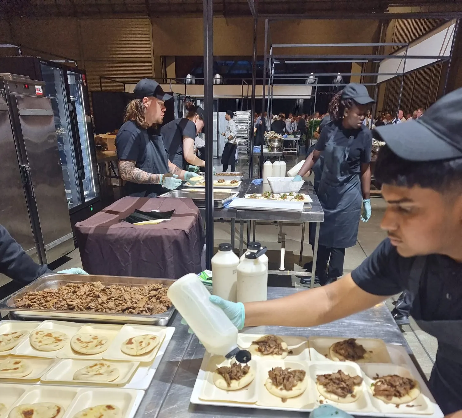 Our uniformed team plating gyros on pita at a large corporate function