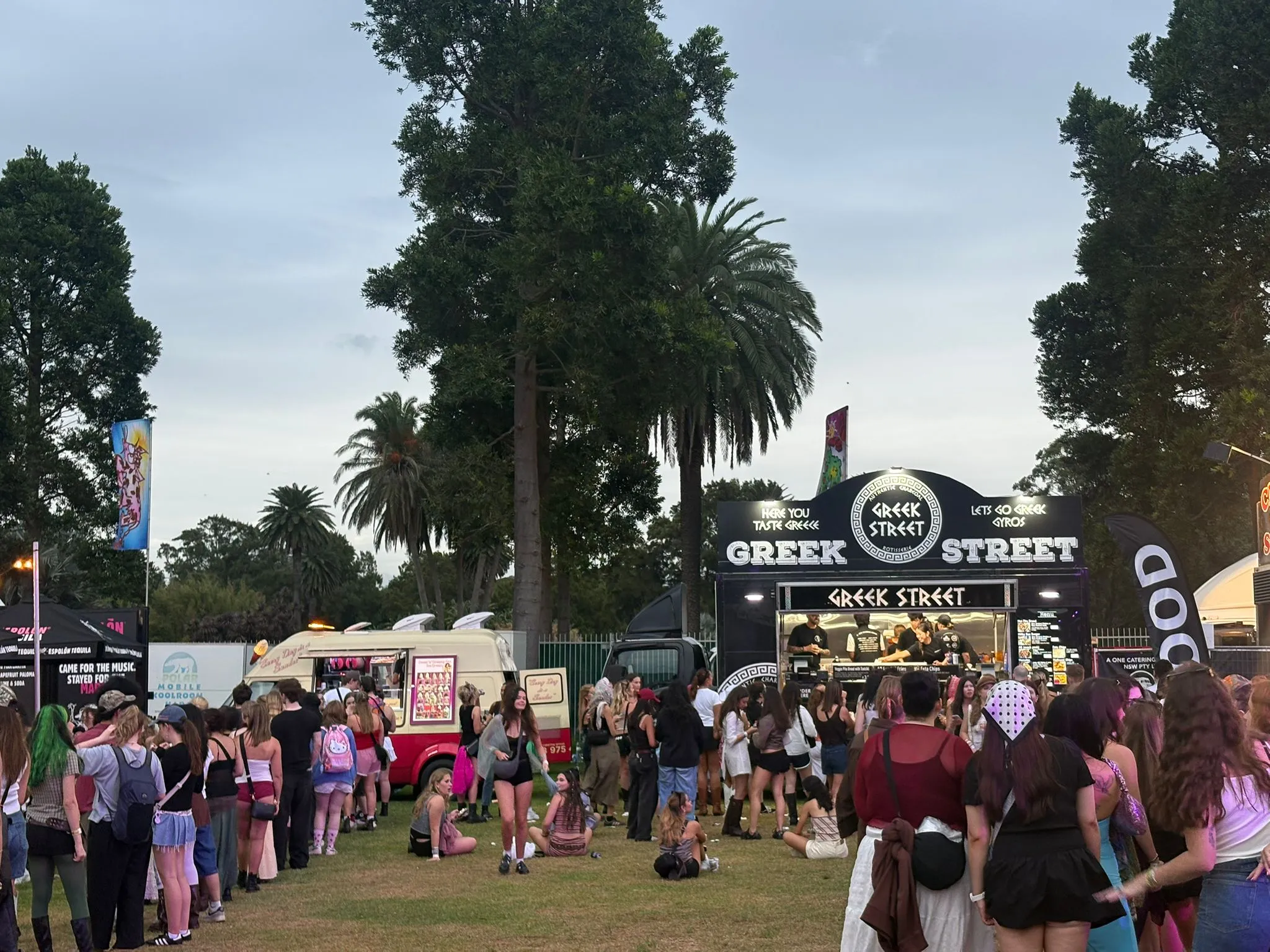 Festival crowds queueing at the Sweet & Creamy ice cream van and the Greek Street truck